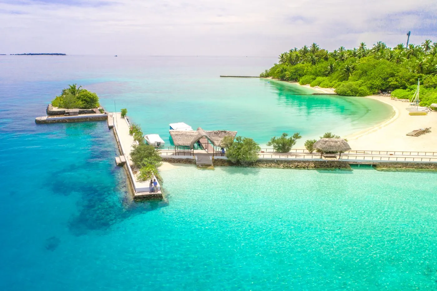 Aerial view of a green tropical island surrounded by clear turquoise water